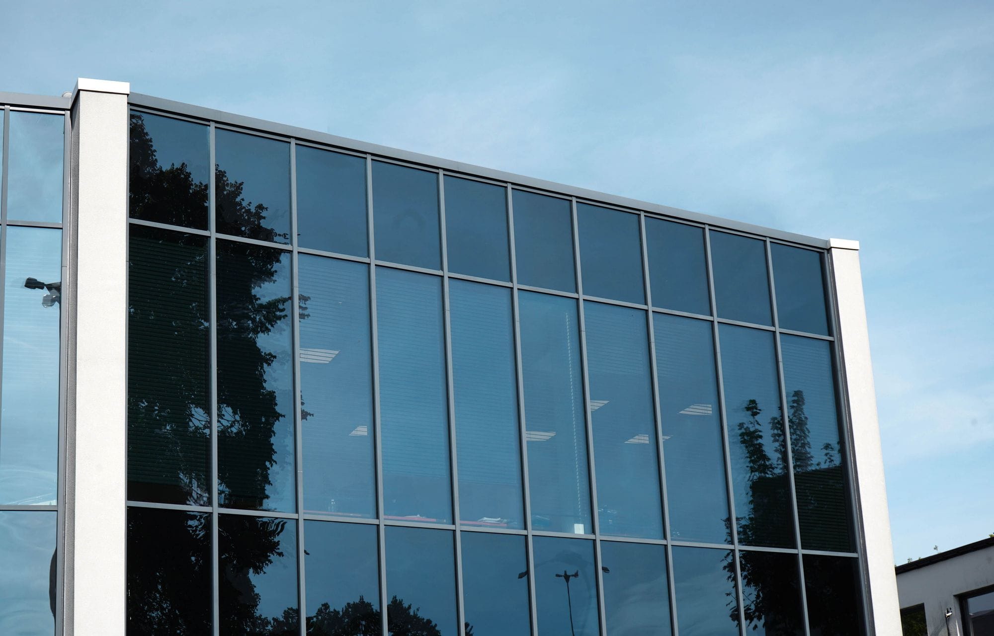 Office building with glass front, blue sky in top background