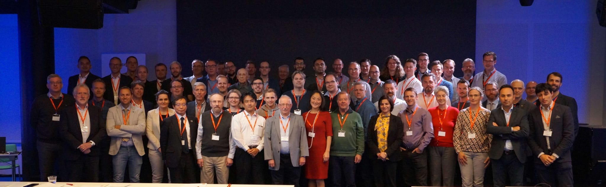 A big group of people with name tags around their necks posing in a group photo