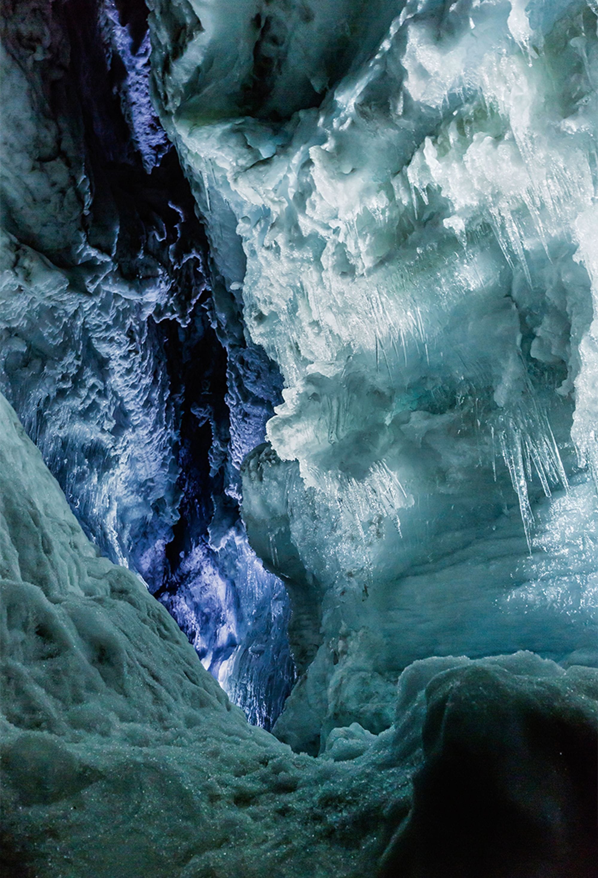 A shot of icy wall and purple light sneaking from a crack 